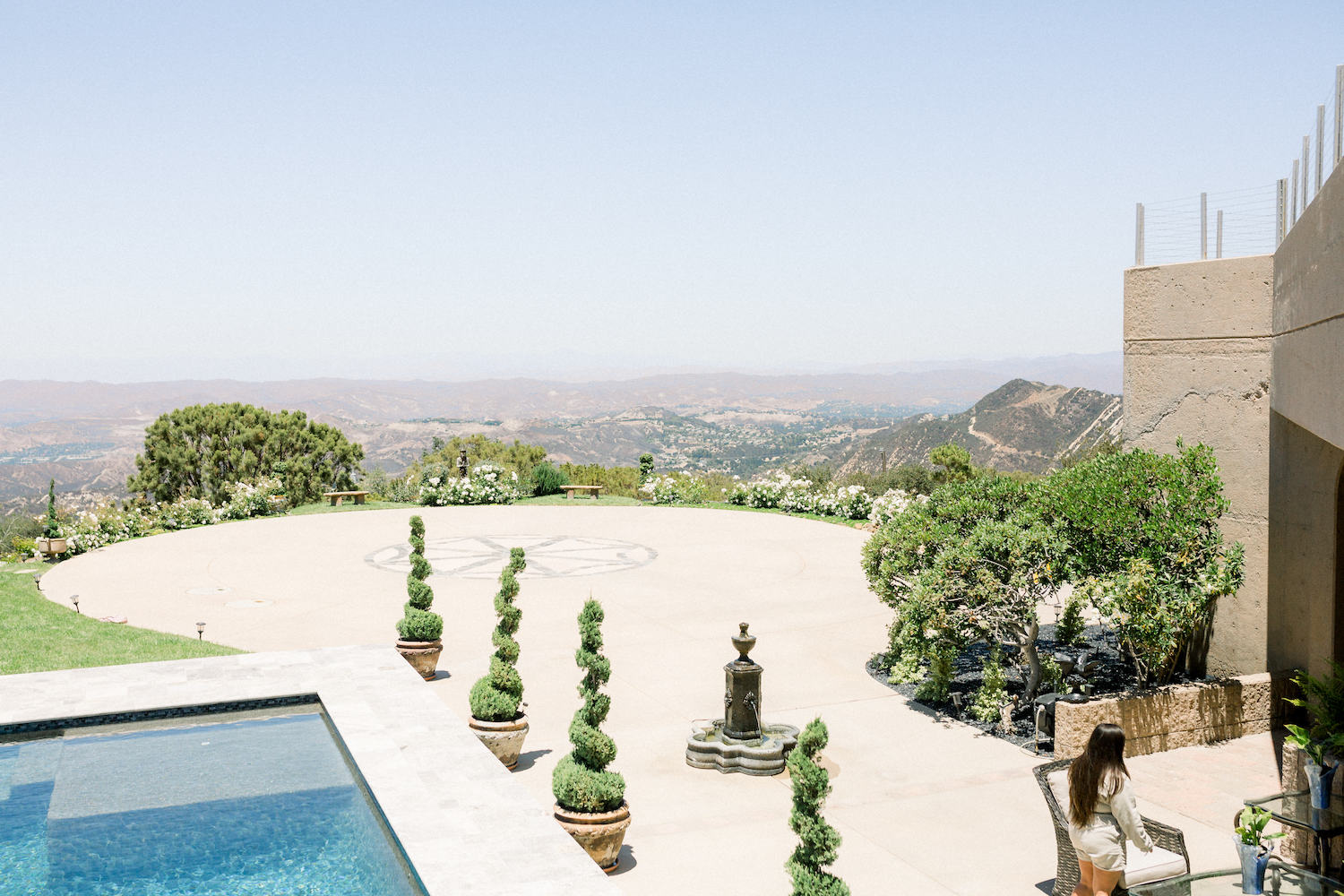 Grass area near the helicopter pad with trees on either side and a pool