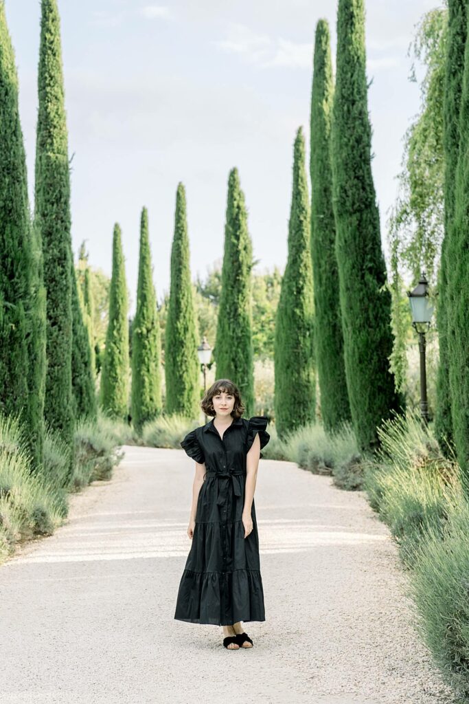 Tuscan luxury wedding resort with destination wedding photographer posing in cypress lined driveway