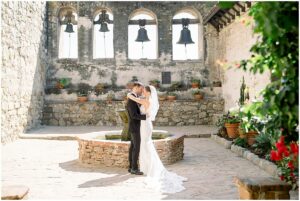 Sophia and Collin posing in courtyard at San Juan Capistrano Mission Wedding.